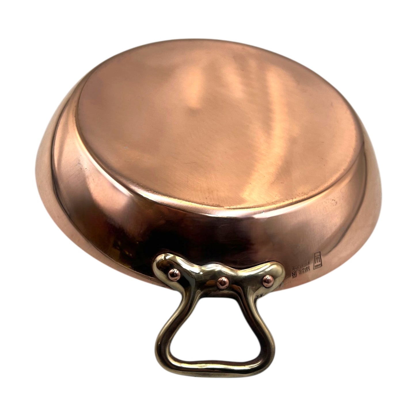 French copper round gratin pan with brass handles on a white background