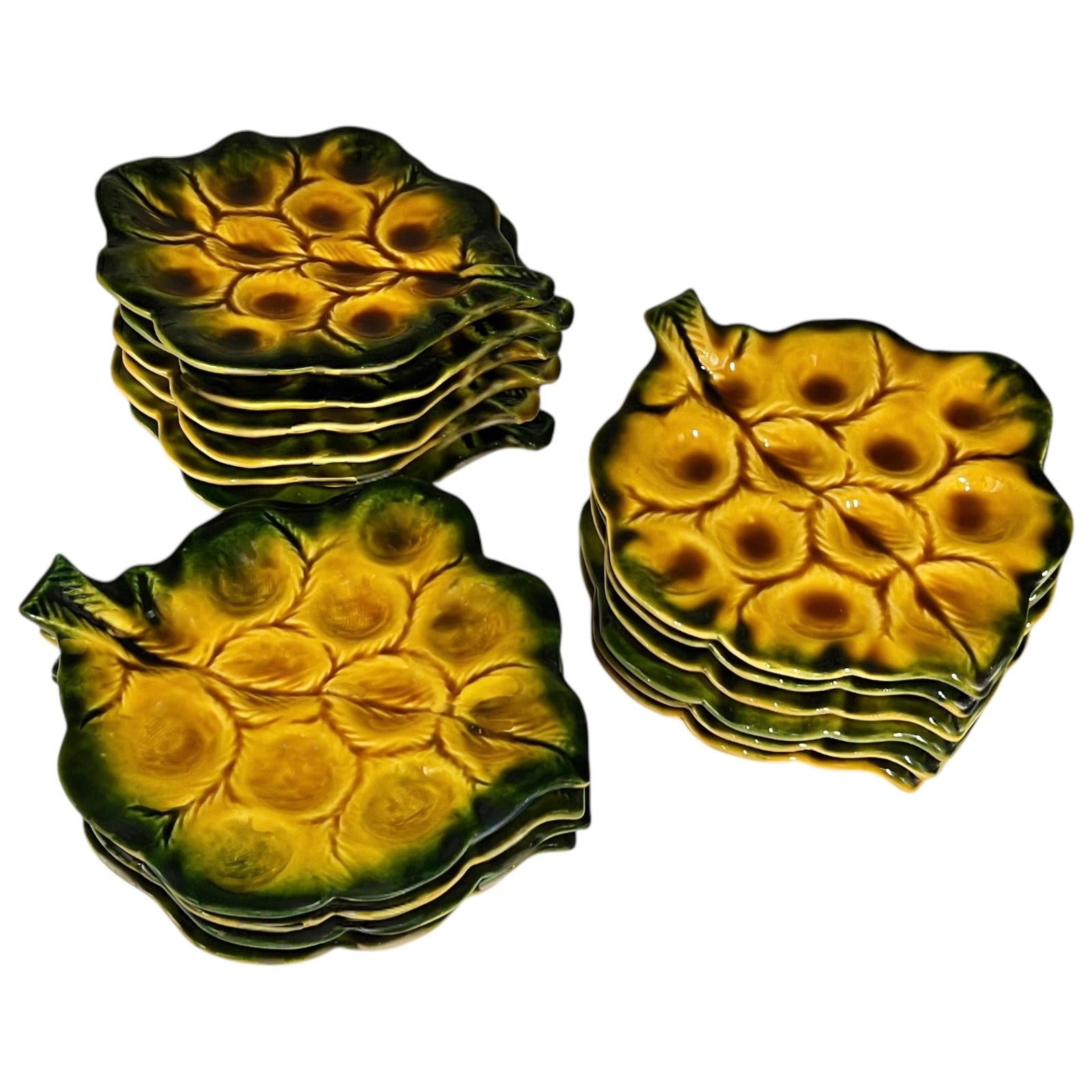 Set of green ceramic leaf-shaped snail escargots plates on a white background