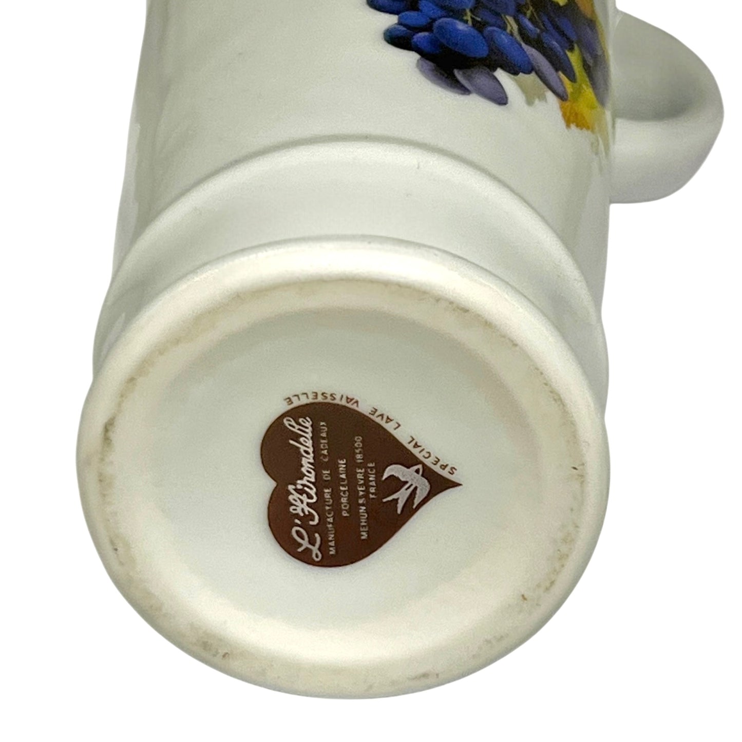Close-up of a porcelain bottle with a brand logo on the base against a white background