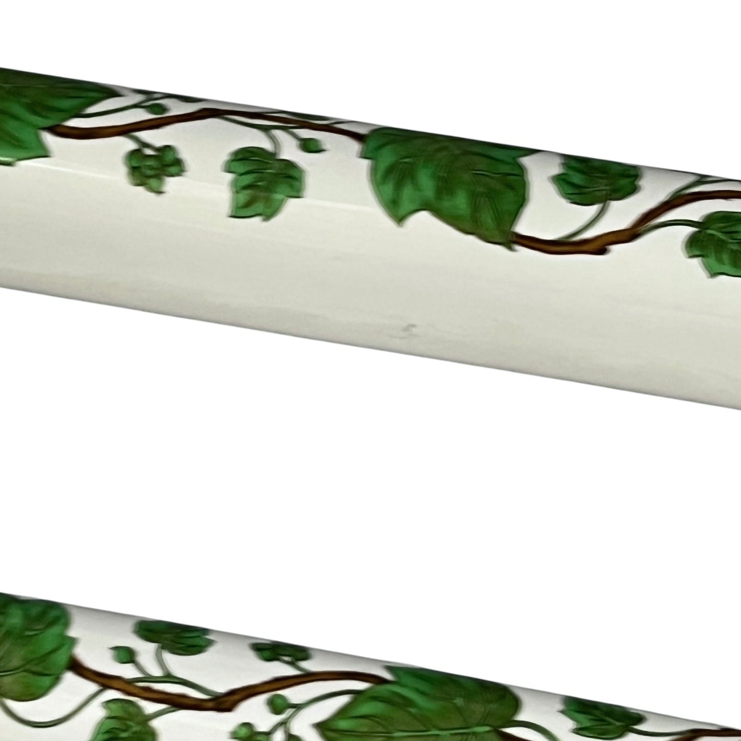 White and green leaf patterned towel rails on a white background