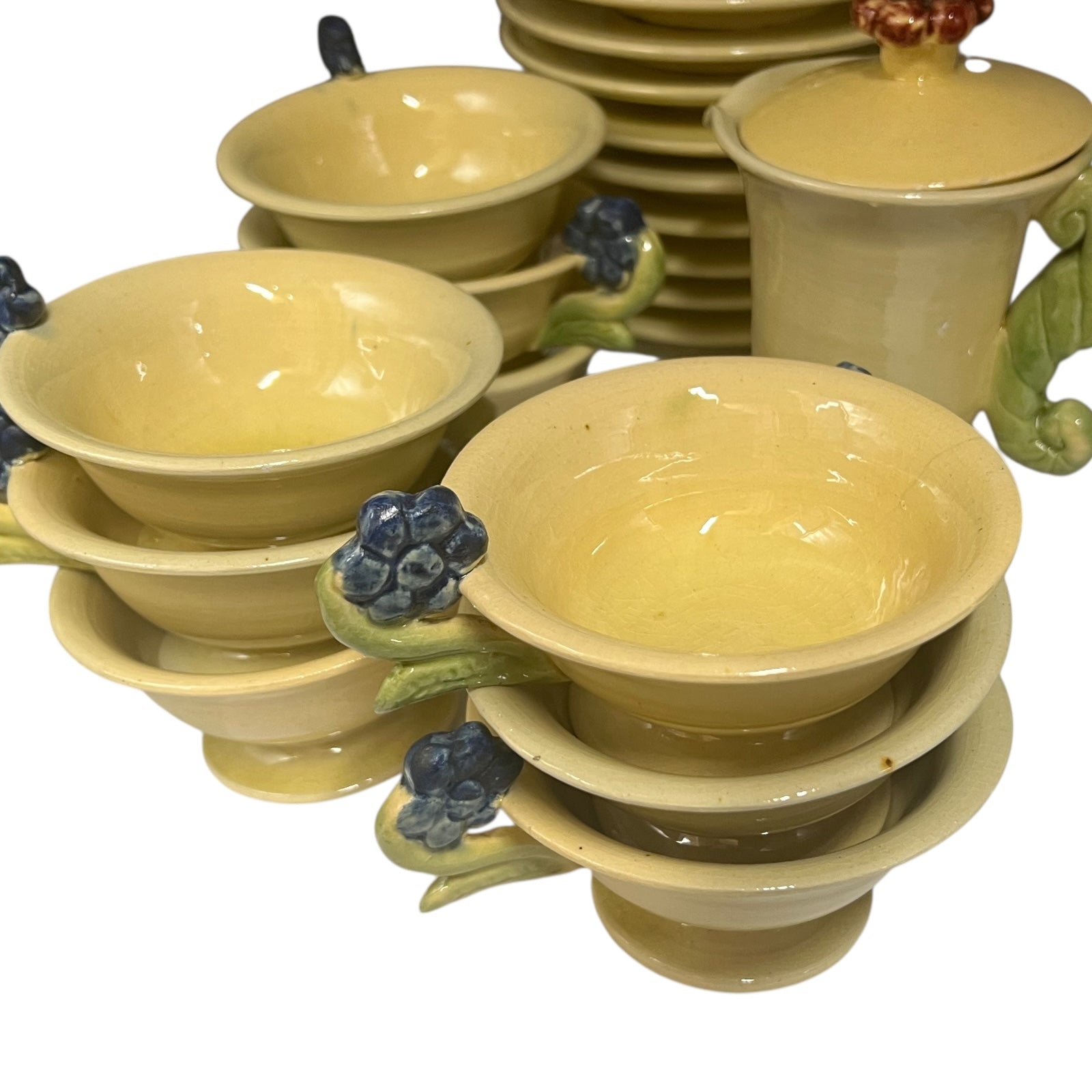 Set of ceramic cups and saucers with floral handles on a white background