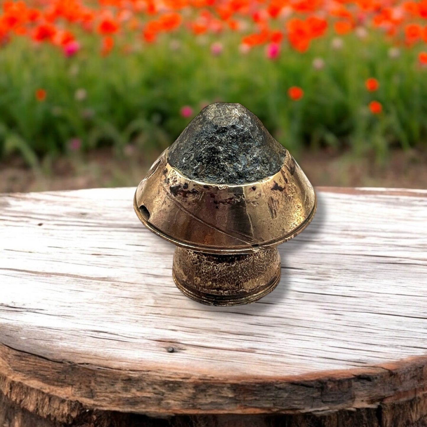 WW1 German Militaria Brass Fuse, great as a WW1 Paperweight on a wooden table in a garden with poppies in the background