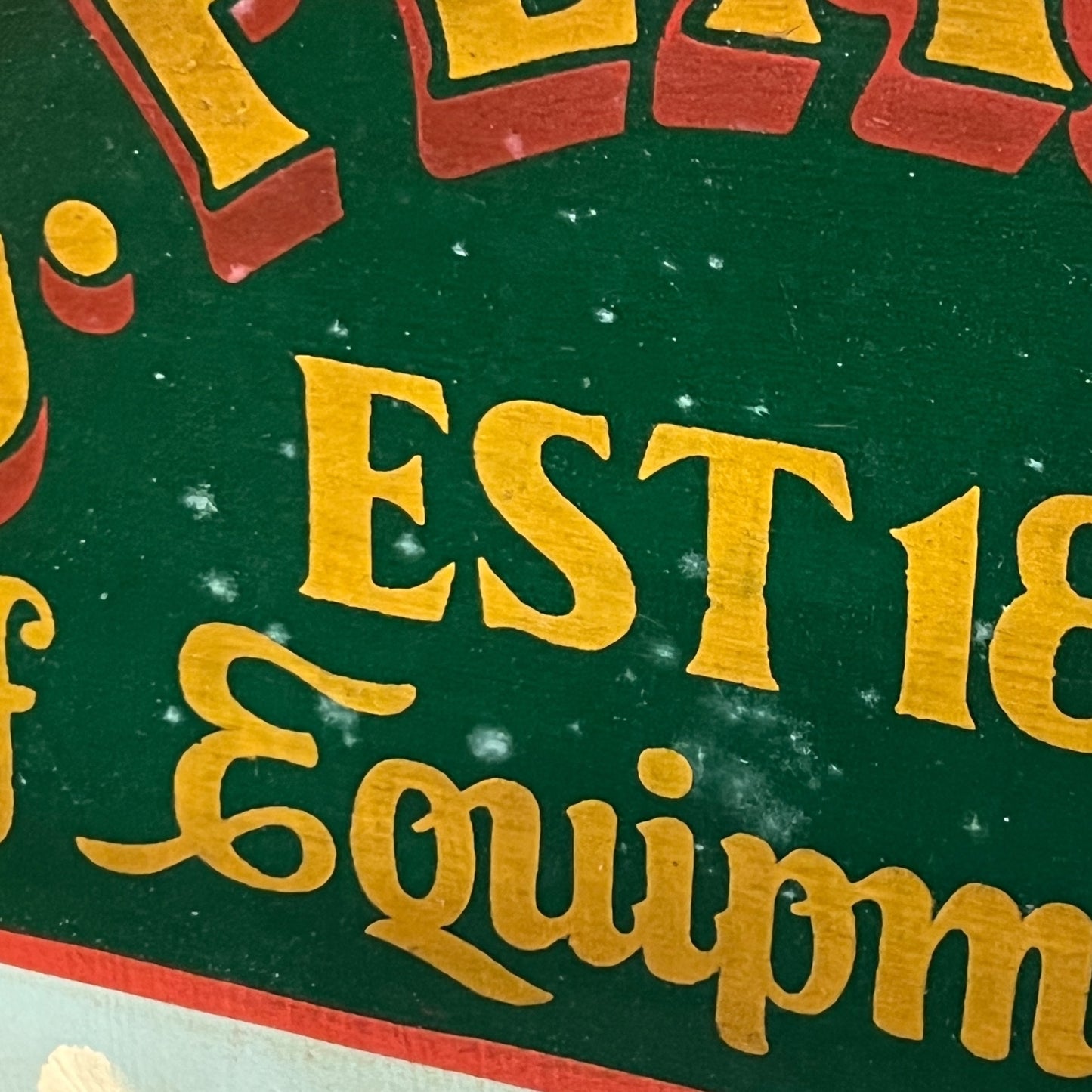 Close-up of a vintage golf sign with 'Equipment' text on a green background