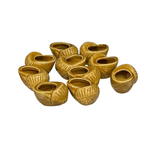 Set of ten miniature vintage French mustard-glazed ceramic snail pots displayed on a white background