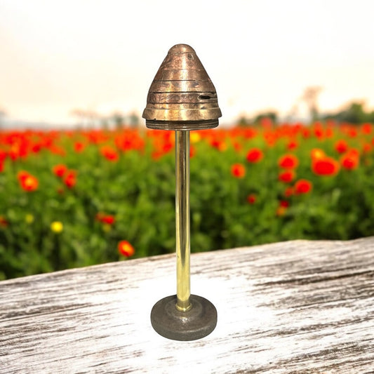 A WW1 British No. 85 brass fuse with internal pipe and base, displayed on a stand, showing signs of age and use for sale from All Things French Store.