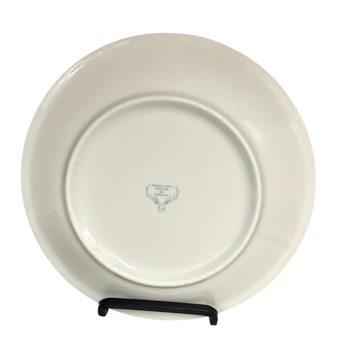 White ceramic plate on a stand with a visible brand logo on a white background