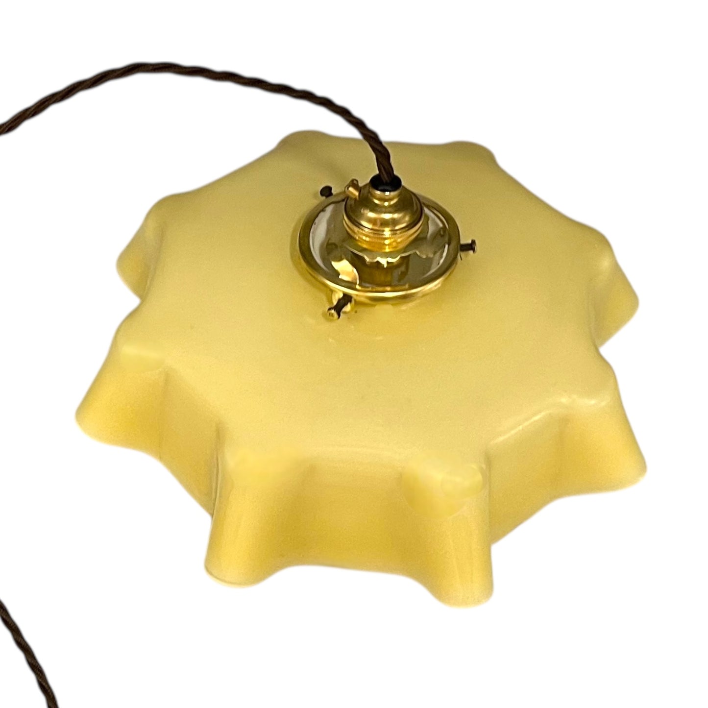 Vintage-style pendant light with a yellow glass shade and brass fitting on a white background