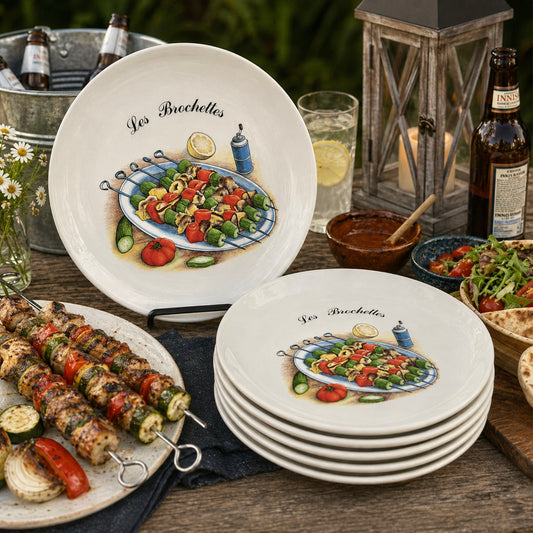 Set of ceramic plates with food illustrations on a wooden table with outdoor setting.