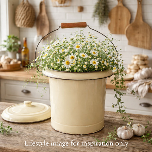 Vintage French Enamel Bucket ideal as a Rustic Planter or Bathroom Storage. Styled on a wooden table in a kitchen and filled with flowers