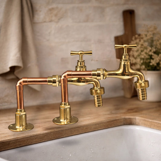 Gold and copper faucets on a wooden countertop with a neutral background