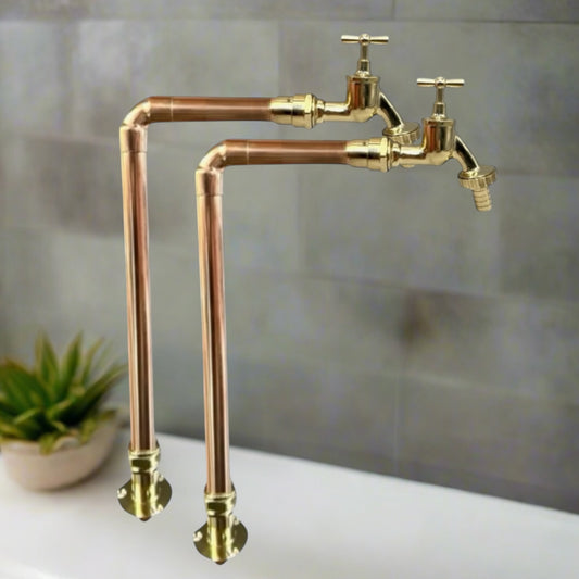 Pair of heritage stye copper and brass tall handmade taps with detachable taps on a dark grey background