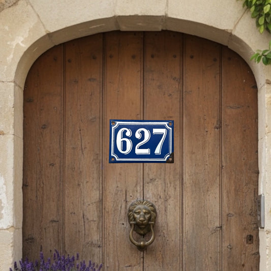 Wooden door with a blue and white number sign '627' and a lion knocker.