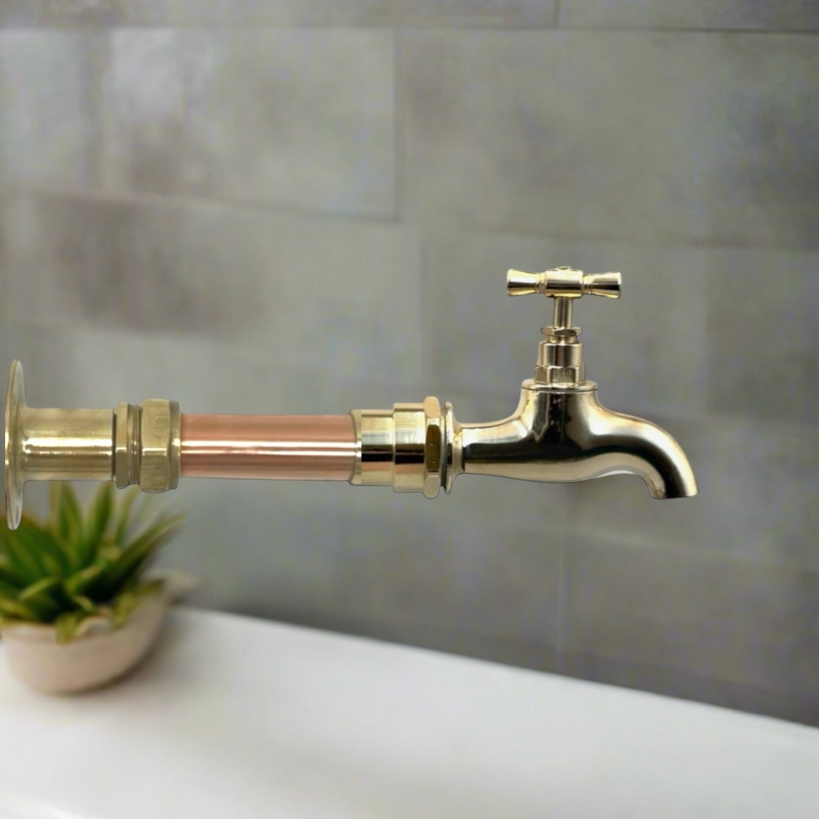 A vintage style copper and brass wall mounted kitchen or bathroom tap