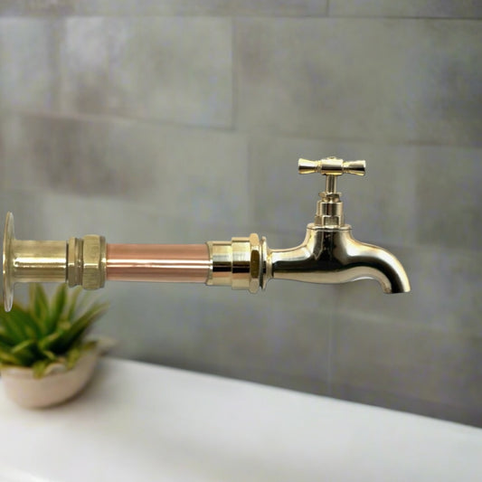A vintage style copper and brass wall mounted kitchen or bathroom tap