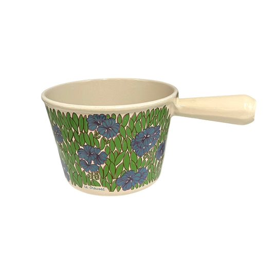 Vintage Le Creuset cast iron fondue pan in rare 1970s floral design, with blue flowers and green leaves, styled on a white background