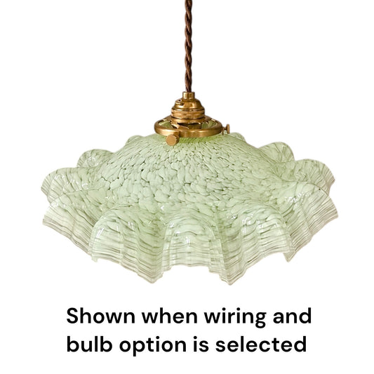 A vintage-style pendant light with a textured, ruffled light green glass shade and a brass-colored metal fixture, suspended by a twisted brown cord. Black text at the bottom reads 'Shown when wiring and bulb option is selected' on a plain white background.