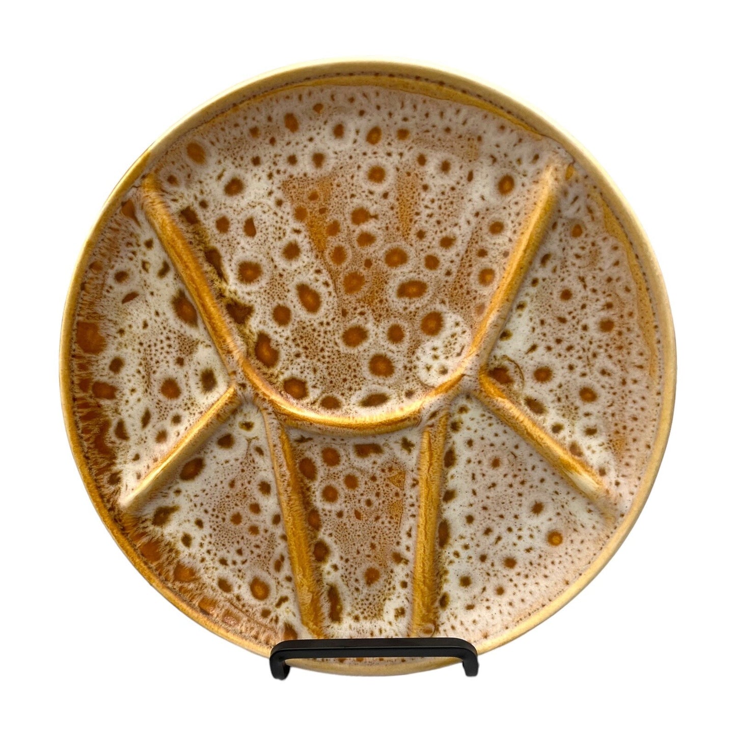 Single amber and white speckled fondue plate made by Niderviller on a white background