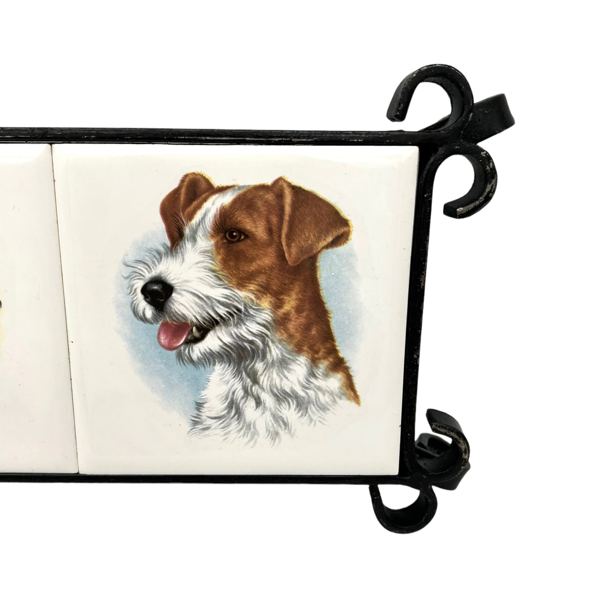 French tile topped pan trivet with an iron frame and 2 tiles -  dog pictures on a white background