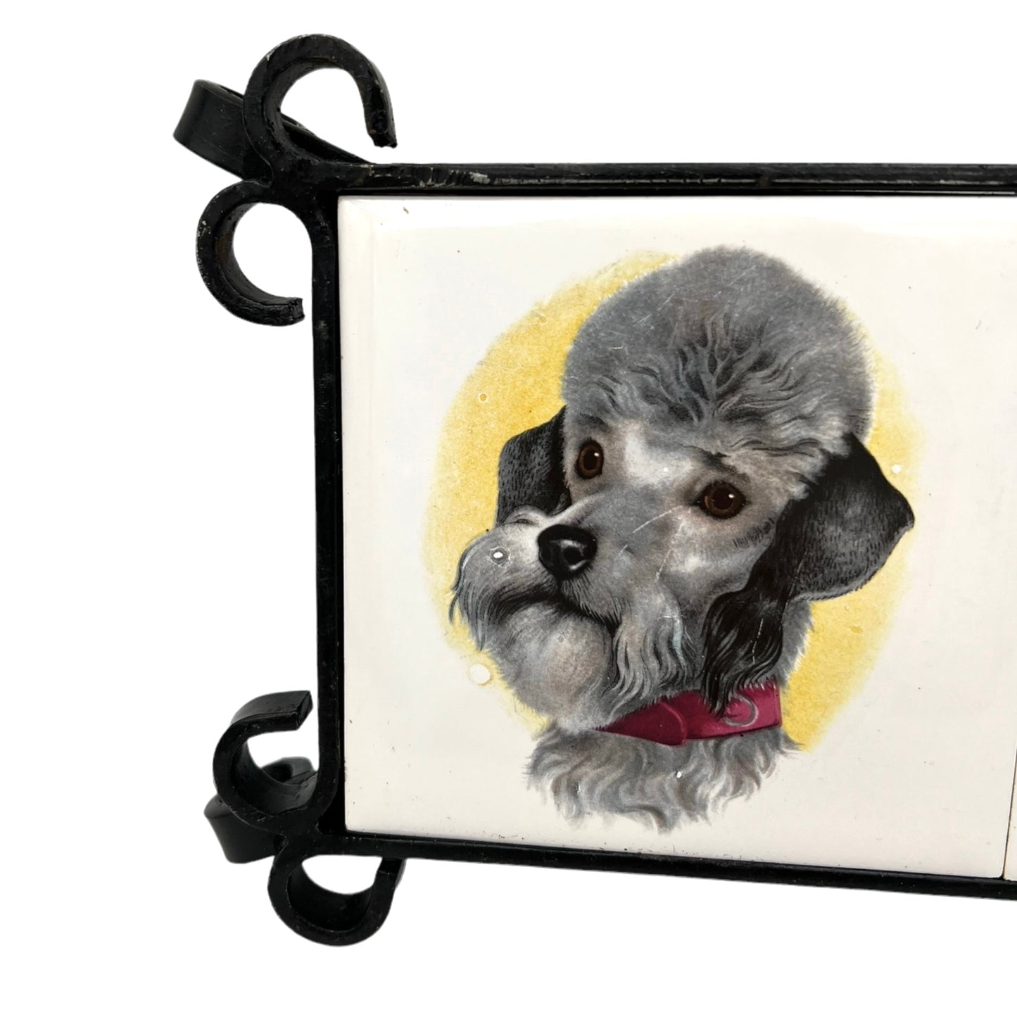 French tile topped pan trivet with an iron frame and 2 tiles -  dog pictures on a white background