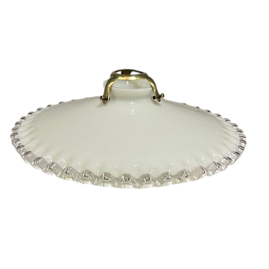 A vintage French milk glass pendant lampshade with a brass gallery holder shown on a white background