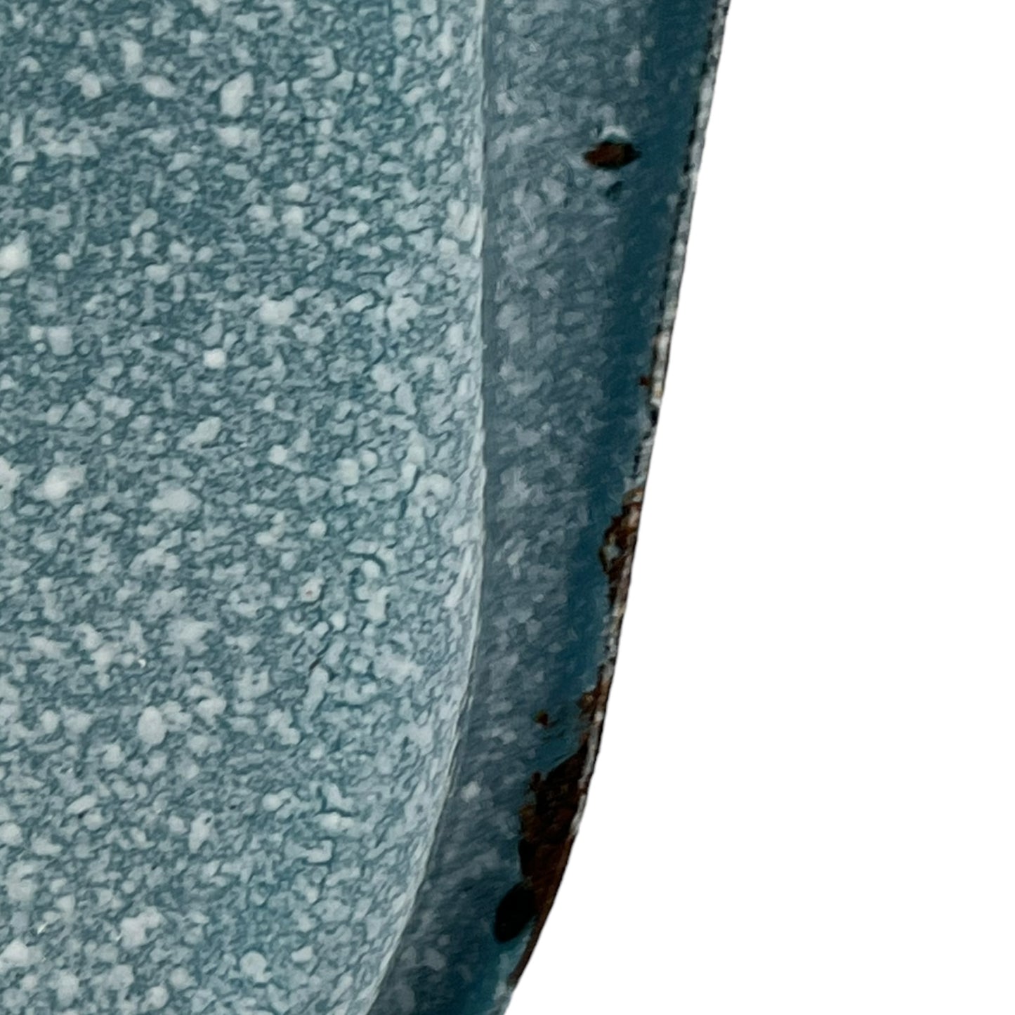 Close-up of wear and tear on a blue metal planter on a white background