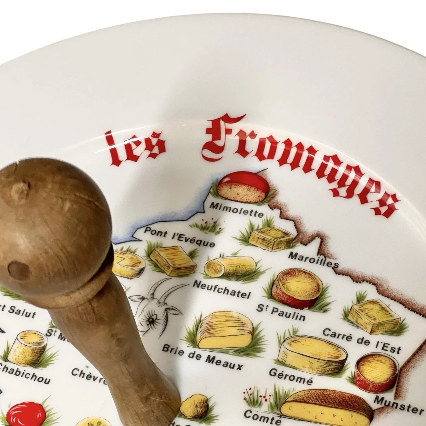 Decorative plate with cheese illustrations and a wooden handle on a white background