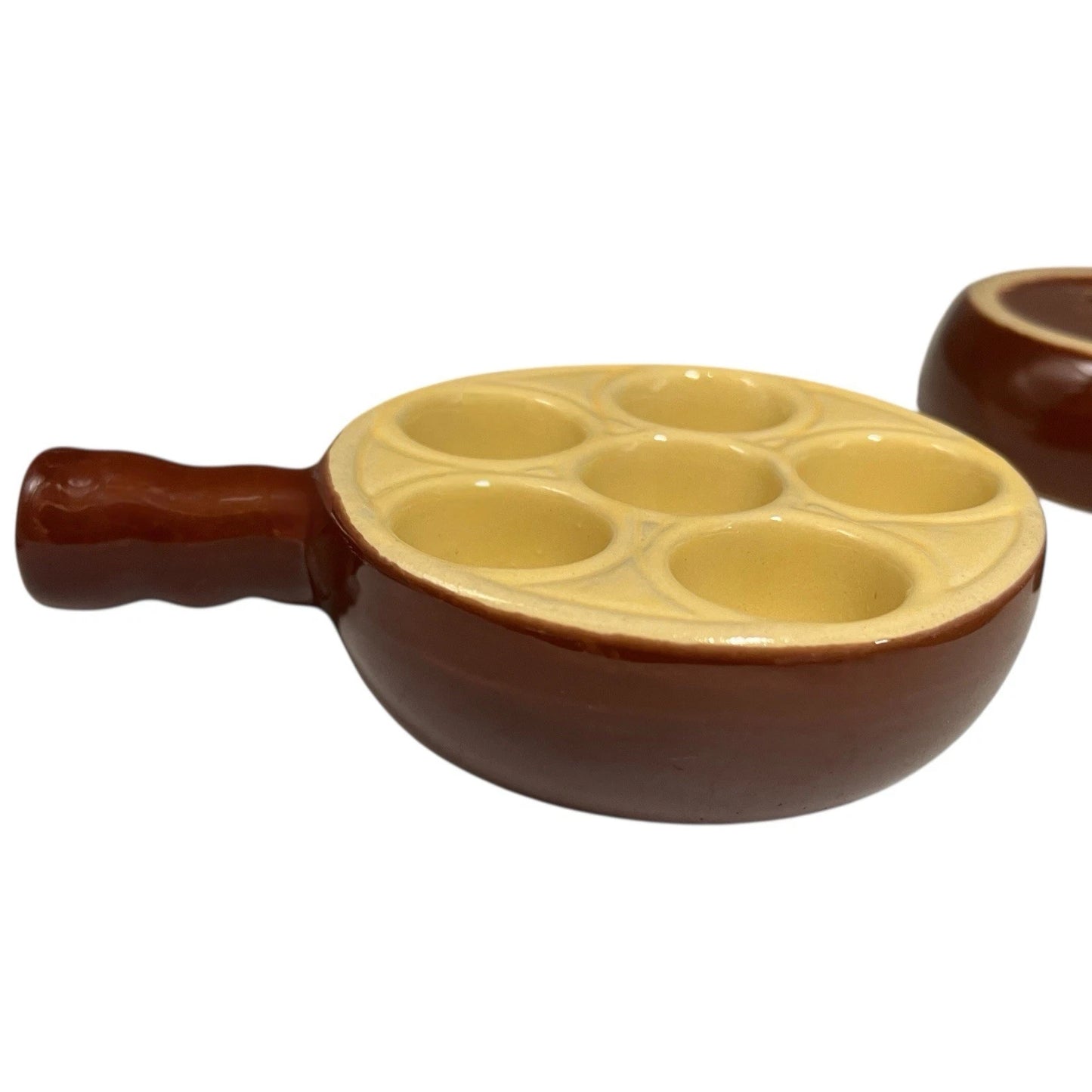 Close up of a French brown and cream ceramic escargots dish or plate with 6 holes on a white background