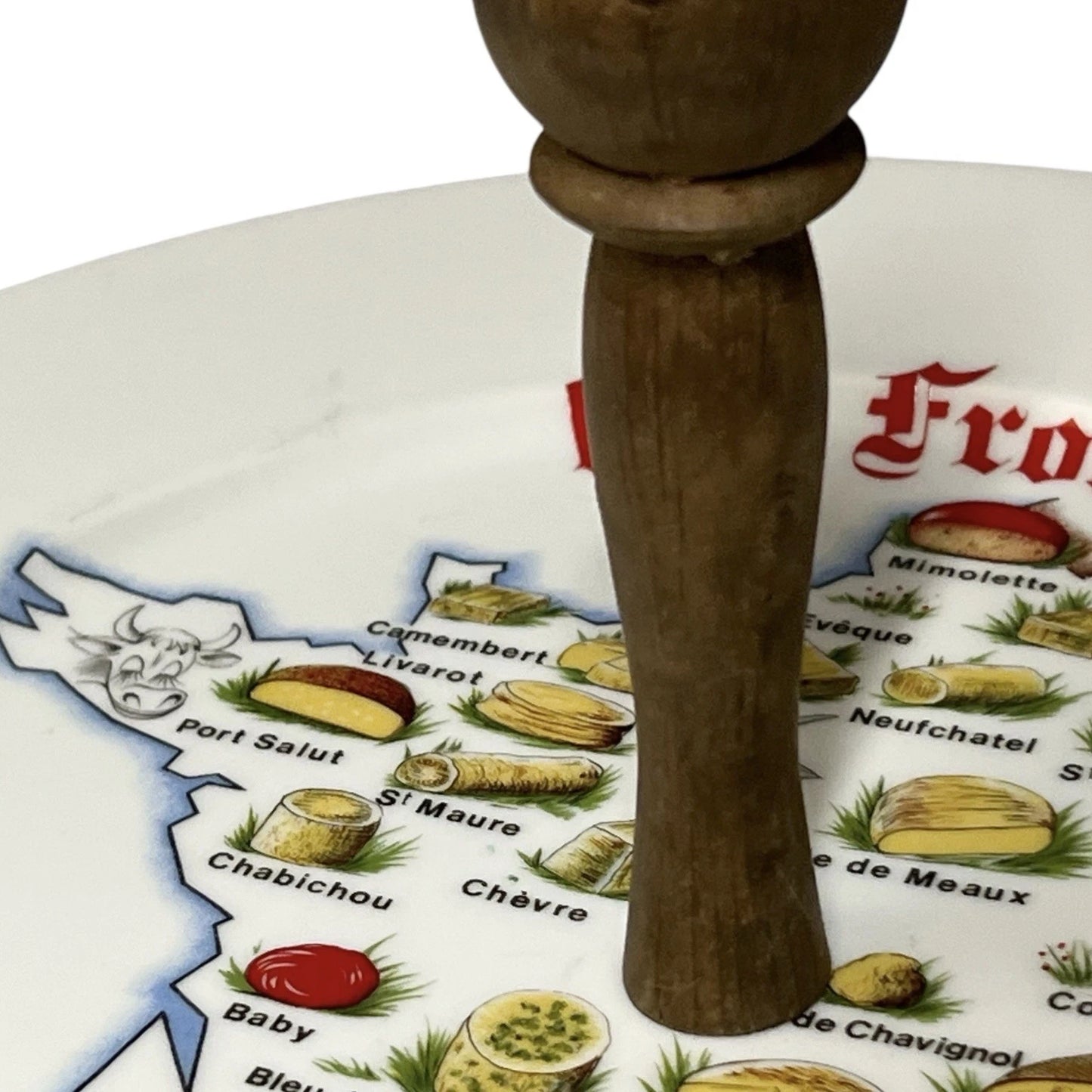 Wooden handle on a decorative plate with cheese illustrations