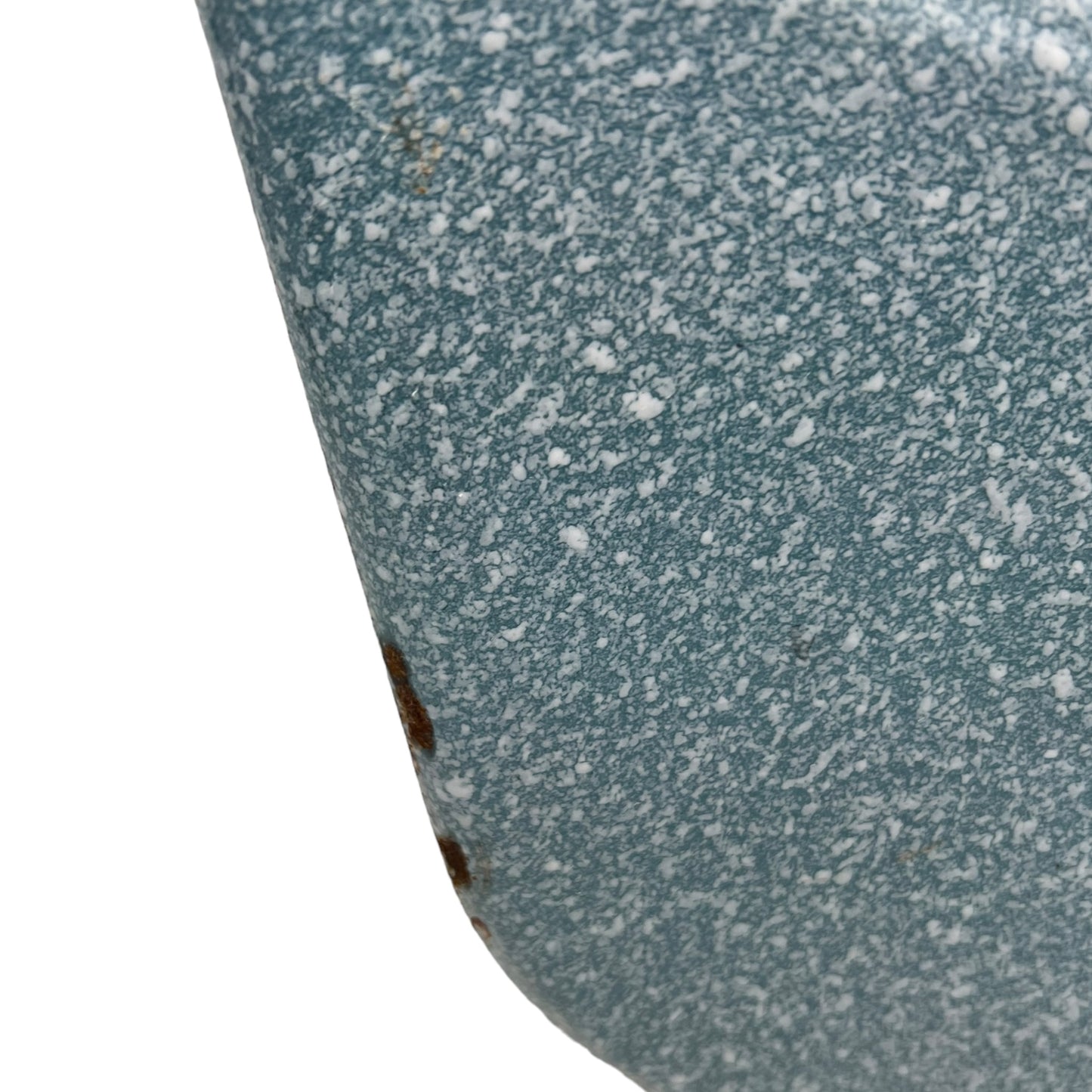 Close-up of wear and tear on a blue metal planter on a white background