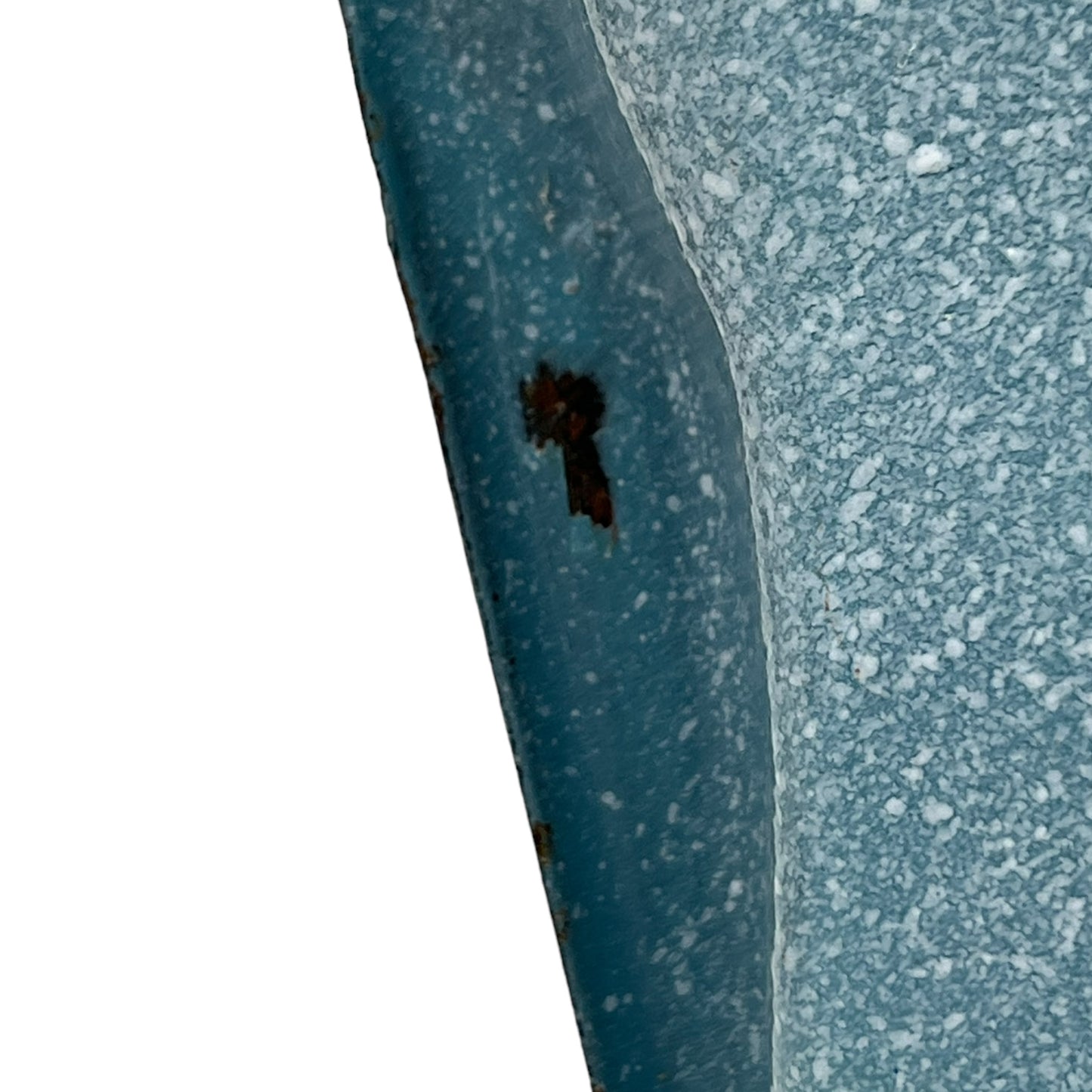 Close-up of wear and tear on a blue metal planter on a white background