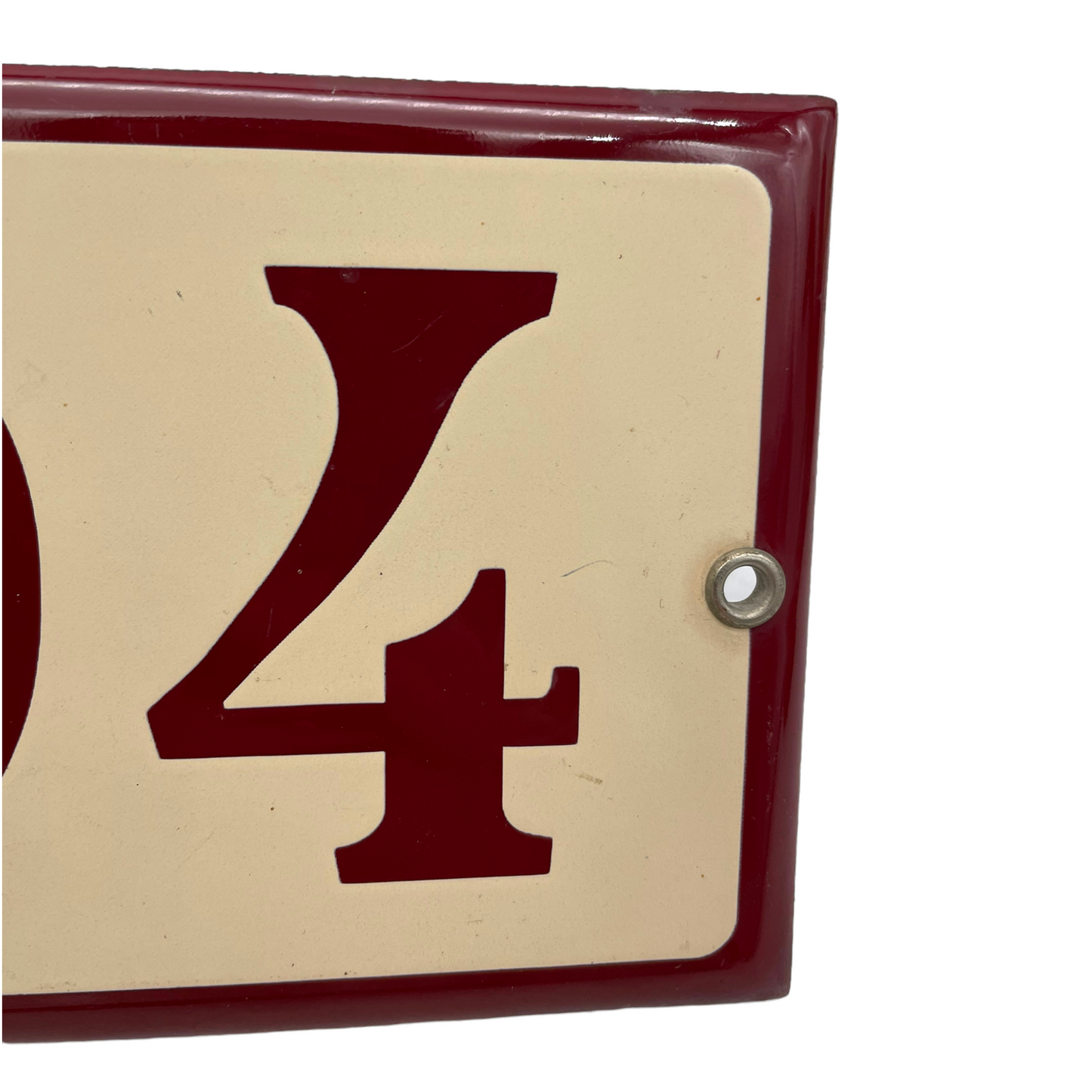 close up of enamel door number showing fixing hole on a white background