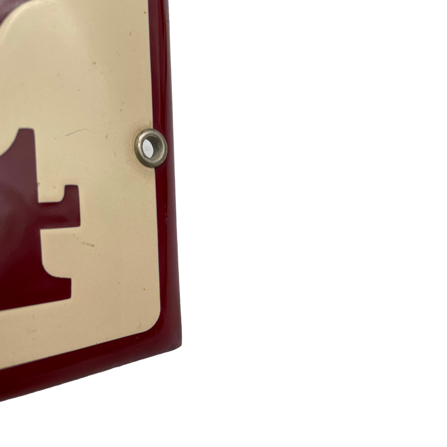 close up of enamel door number showing fixing hole on a white background