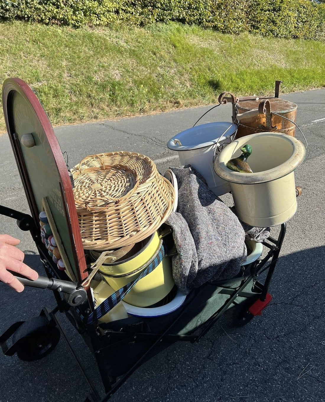 A trolley full of vintage market finds being pushed down a road