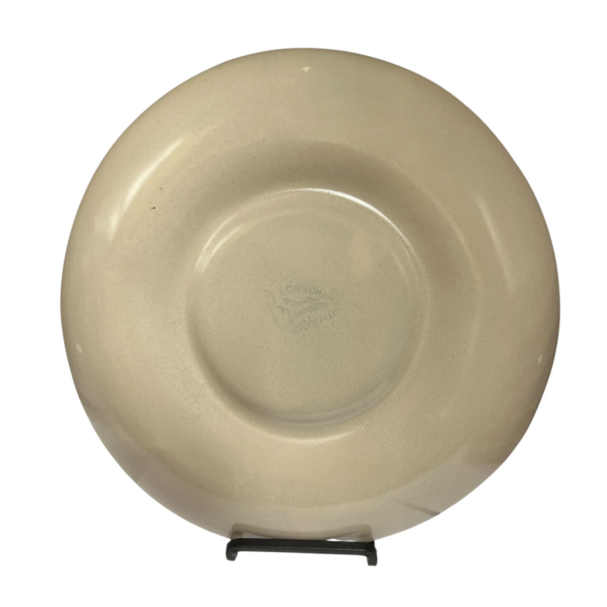 A round ceramic plate in a warm cream or light beige color, displayed upright on a small black stand against a plain white background.