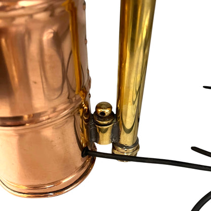 Close-up of a copper and brass lamp with visible wiring on a white background