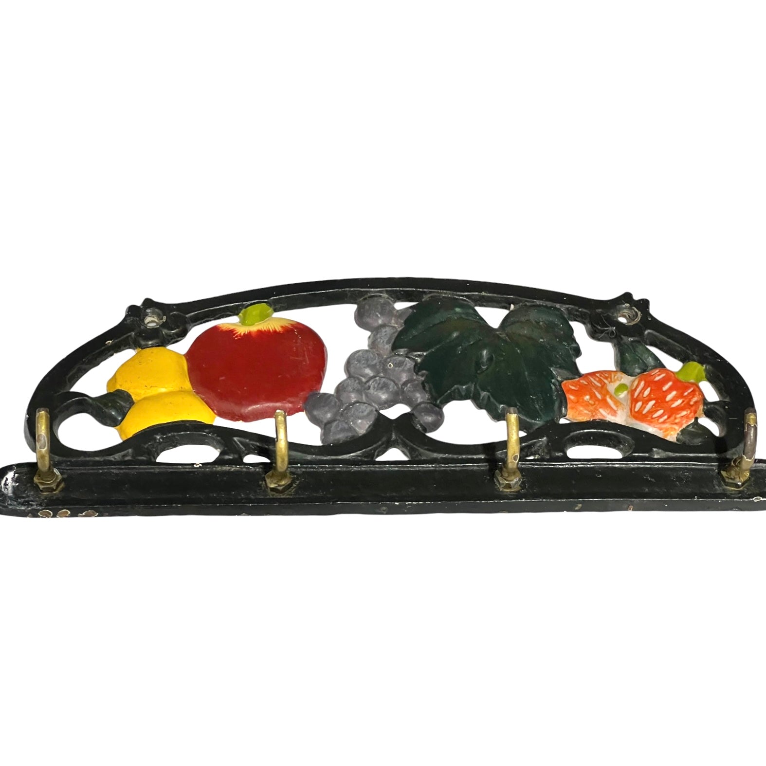 A vintage cast iron fruit and vegetable holder with a black arched frame decorated with colorful enamel-style fruits and leaves, featuring four gold-toned hooks.