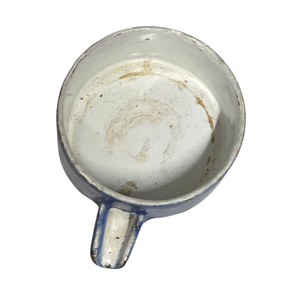 Close-up of a vintage fruit press with a blue pot on a white background