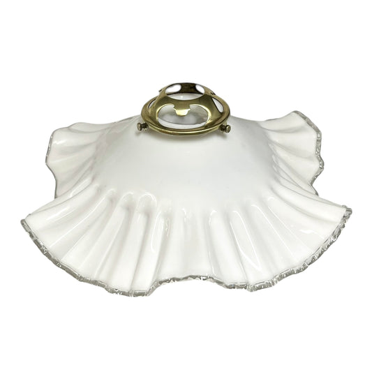 White scalloped lampshade with brass fitting on a white background
