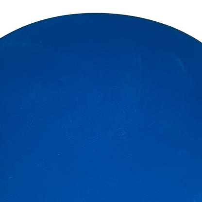 A close-up of a solid blue circular or domed surface with a white background visible at the top edge.