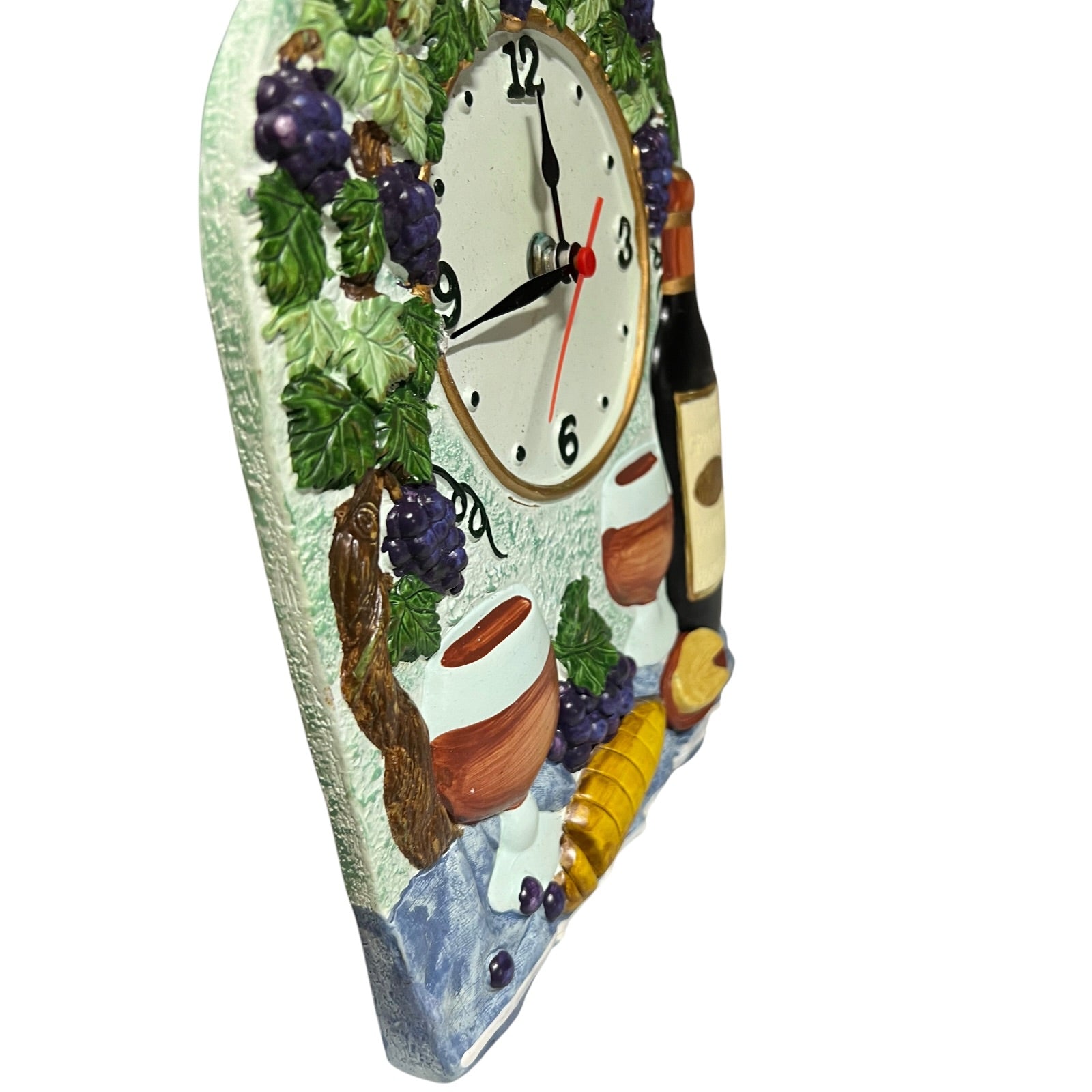 A decorative wall clock with a rustic Italian wine theme, featuring raised grapes, bowls, a bottle, and a wine glass on a white background.