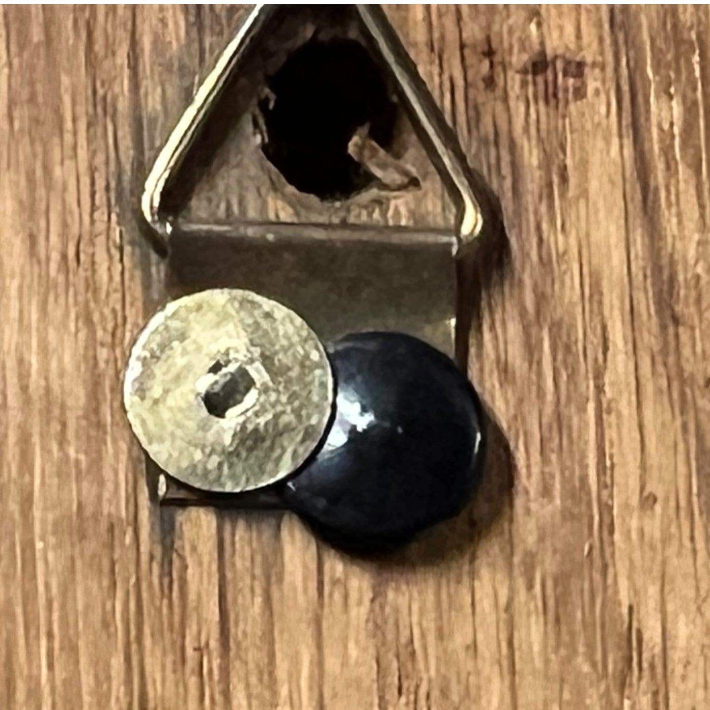 Close-up of a bottle opener with two bottle caps on a wooden surface