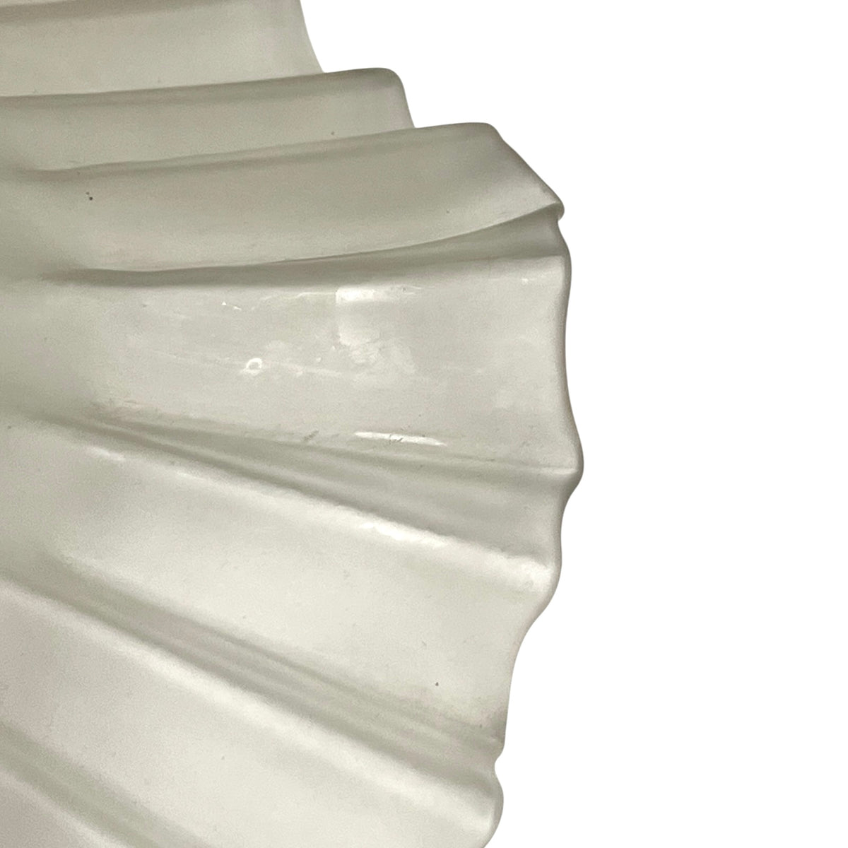 A close-up of a translucent glass shade or mesh material with a scalloped edge, shown against a plain white background.