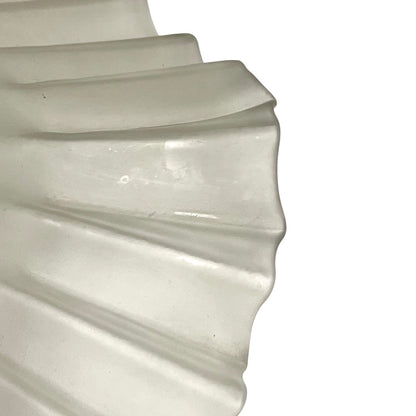 A close-up of a translucent glass shade or mesh material with a scalloped edge, shown against a plain white background.