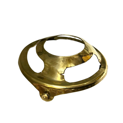 A polished brass circular metal component with a textured, hammered finish and a small threaded screw detail, isolated on a white background.