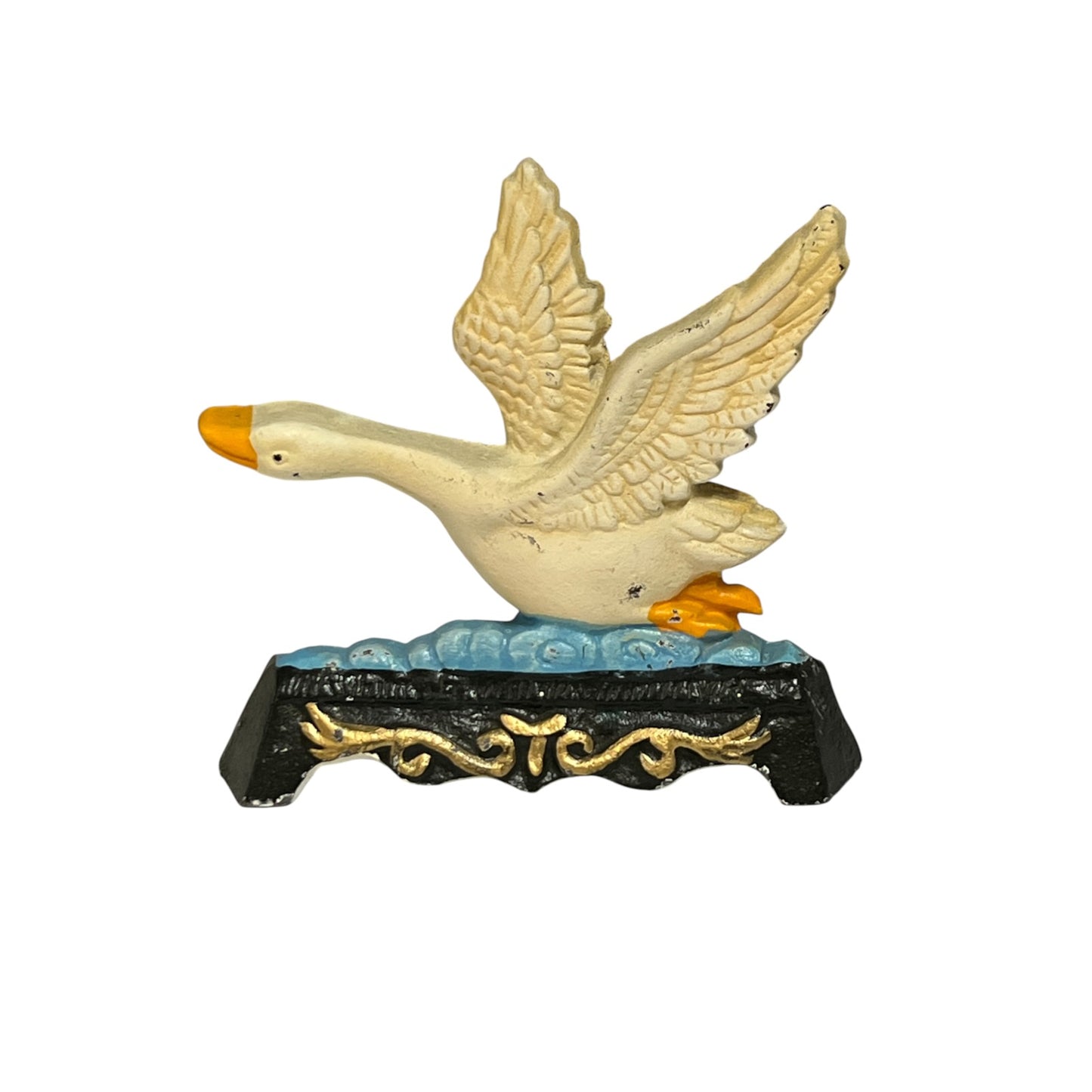 A decorative cast iron duck figurine with wings raised, standing on a blue wave-patterned base with a black and gold ornate pedestal. The duck has an off-white body with a yellow-orange beak and webbing, set against a plain white background.