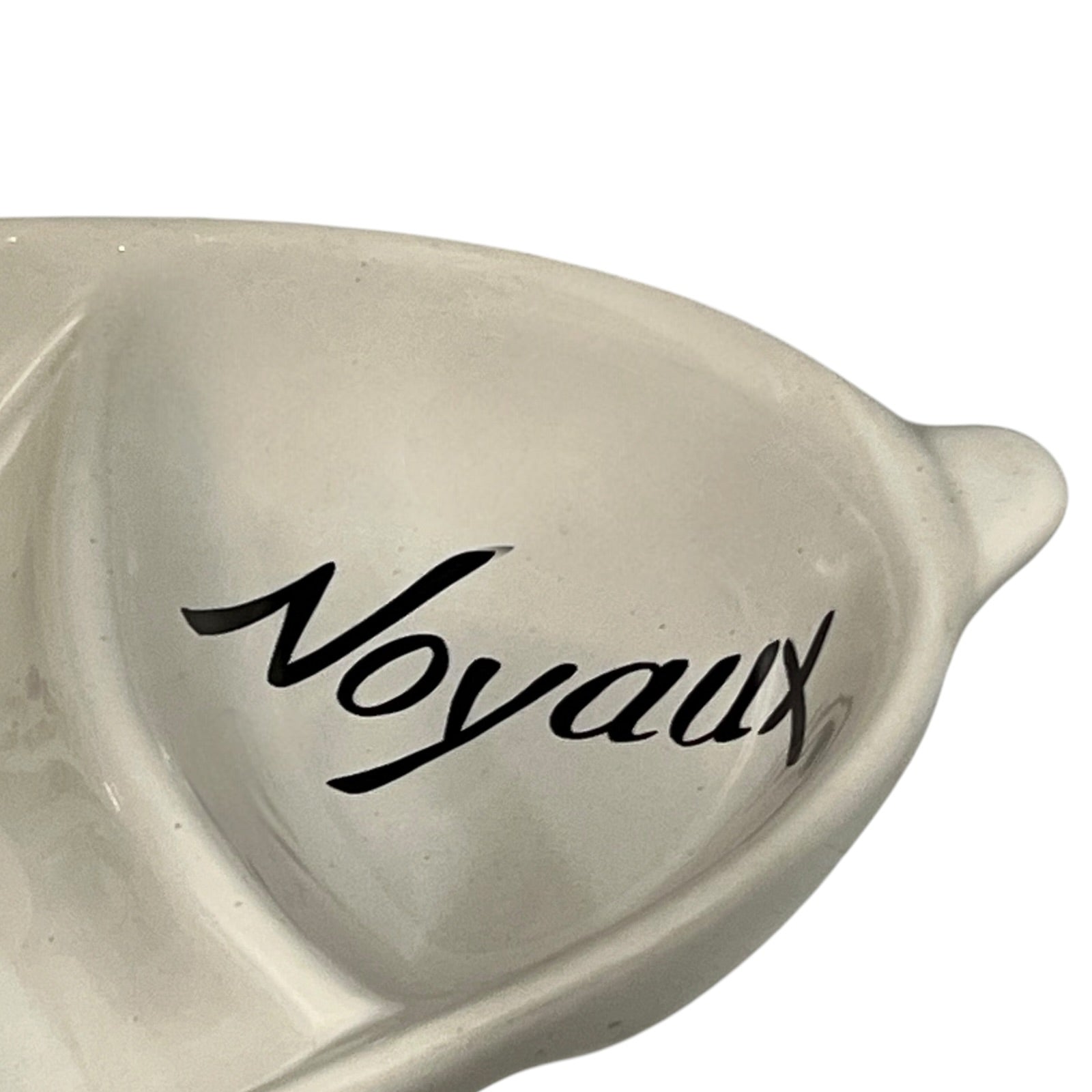 Heart-shaped ceramic dish with 'Noyaux' text on a white background