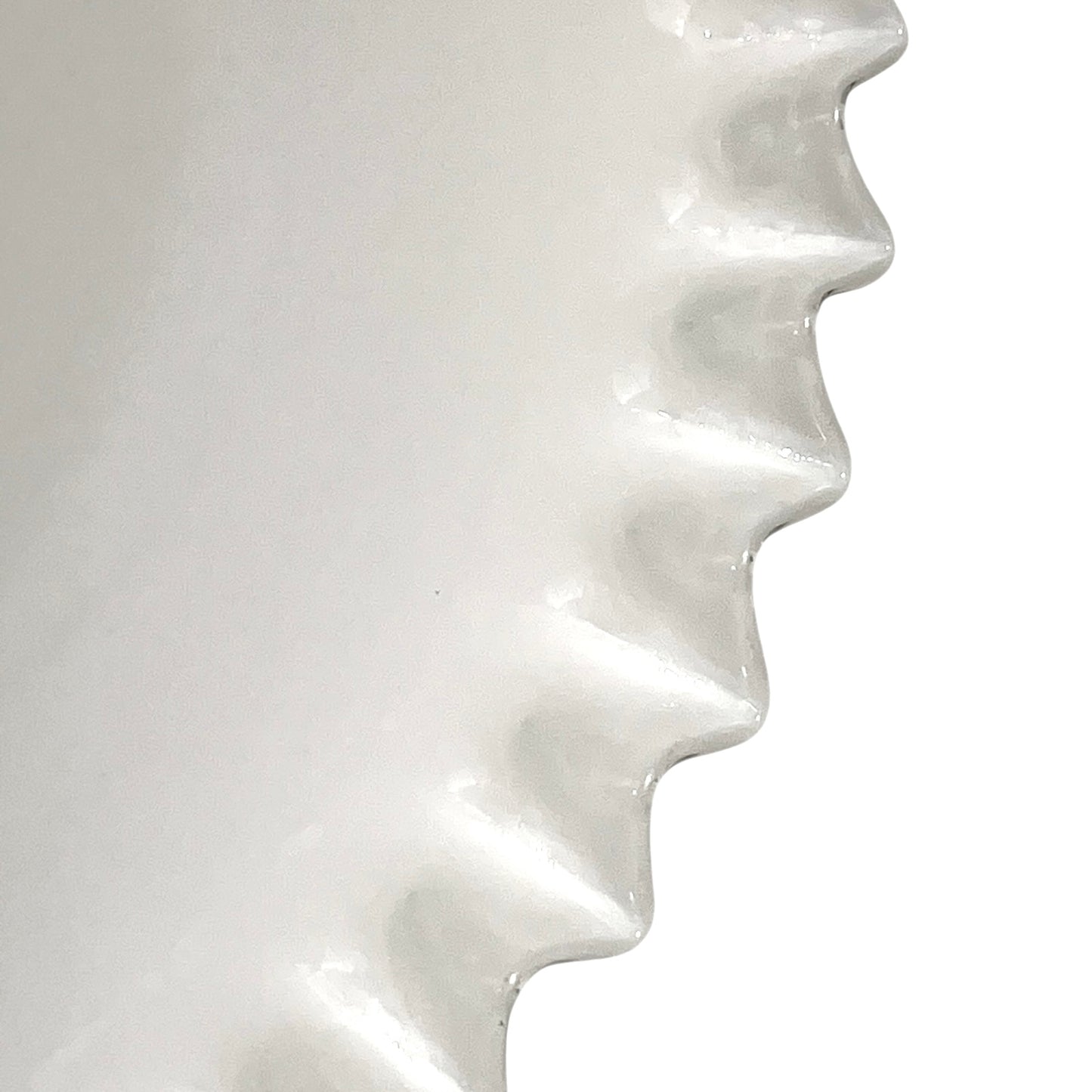 Close-up of a white glass lampshade with wavy design on a white background