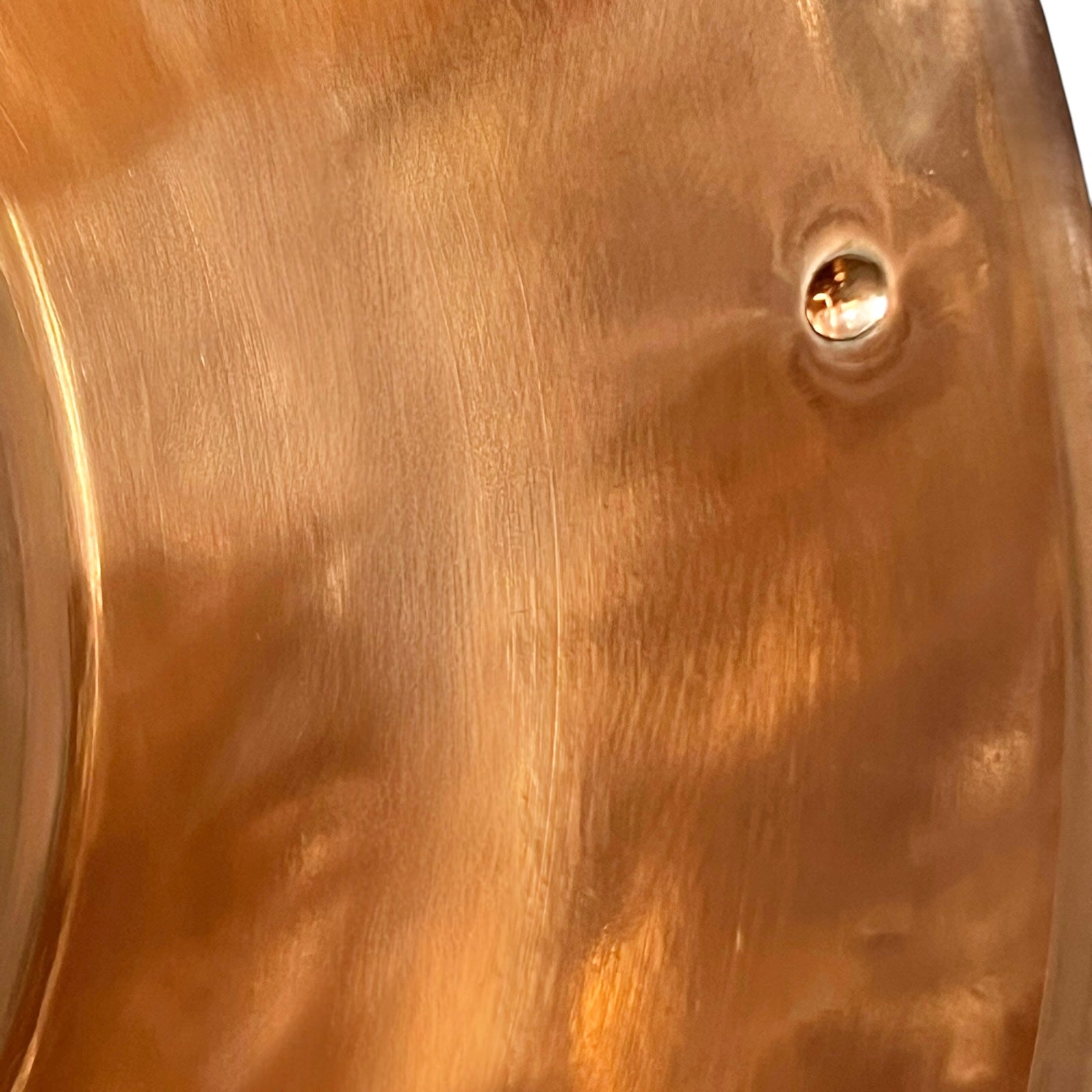 Close-up of a copper basin with a reflective finish on a white background 