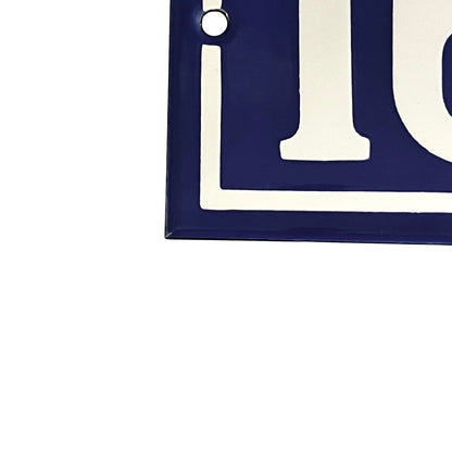 Close-up of a dark blue square sign or plaque with large white lettering and a small round mounting hole near the top left, shown on a white background.