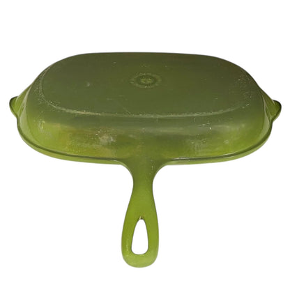 Green Le Creuset grill pan with black cast iron inner on a white background